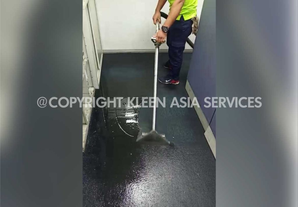 technician using water extraction machine extracting flood water from carpet
