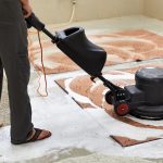 tchnician using scrubbing machine cleaning rug